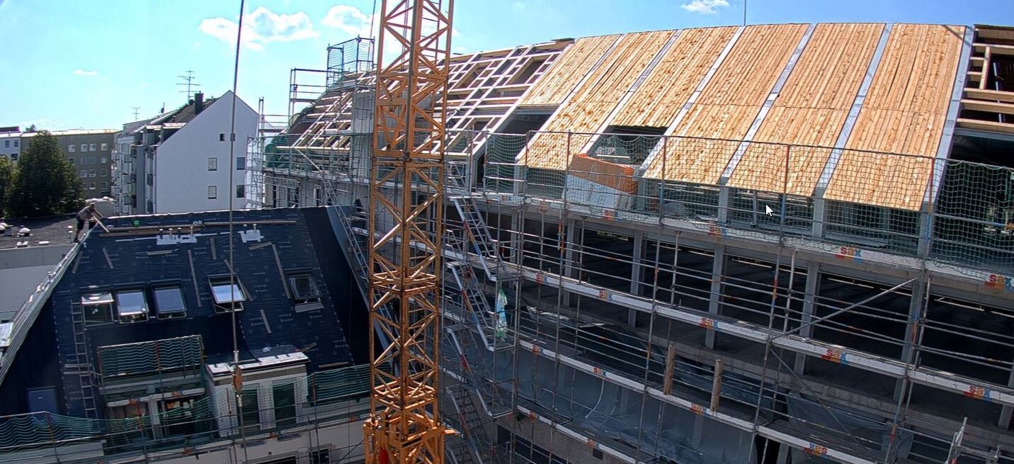 Baustelle mit gelbem Kran, Gerüstbau und Holz-Dachkonstruktion, Arbeiter sichtbar