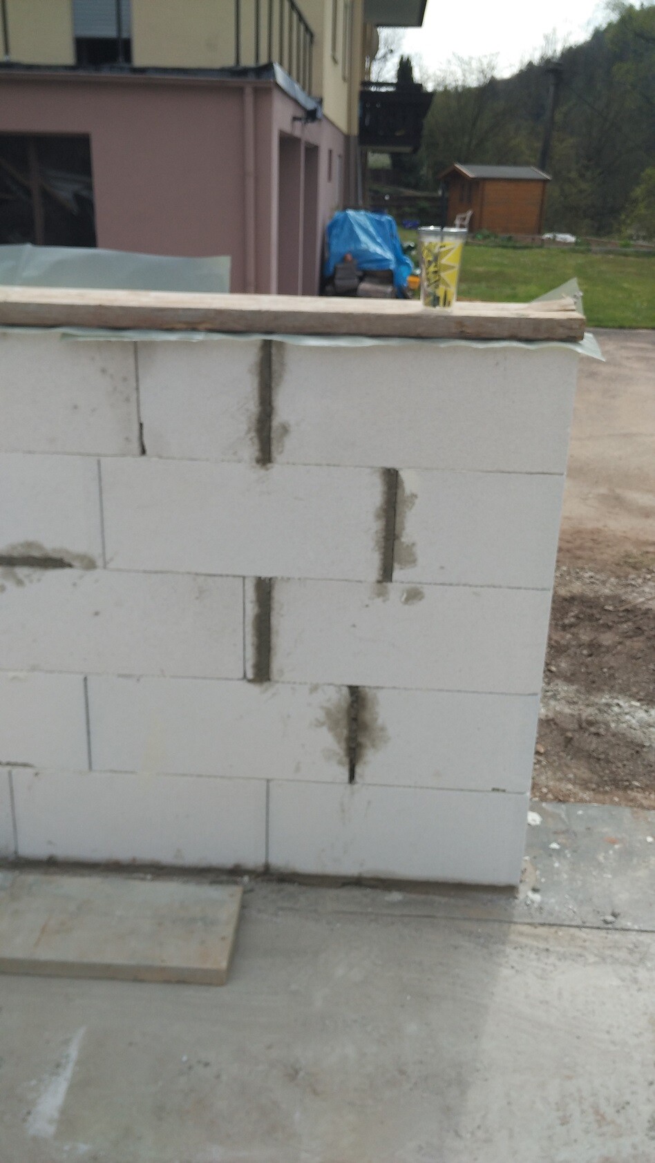 Weiße Porenbetonblöcke bilden eine Wand im Rohbau auf einem Bauplatz.