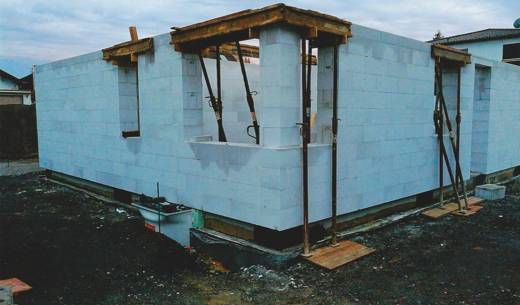 Rohbau eines Hauses mit blauen Porenbeton-Wänden und Stützstreben auf einer Baustelle