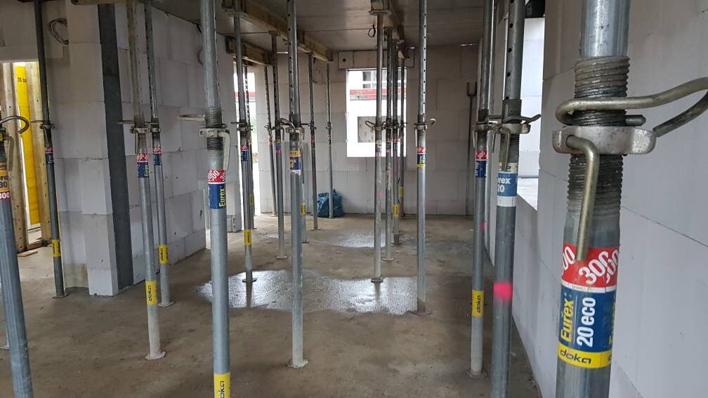 Innenraum einer Baustelle mit vielen Stahlstützen und verstellbaren Stützsäulen.