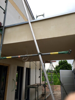 Außenansicht einer Baustelle mit Gerüsten am Rohbau und Fassadenelementen sichtbar