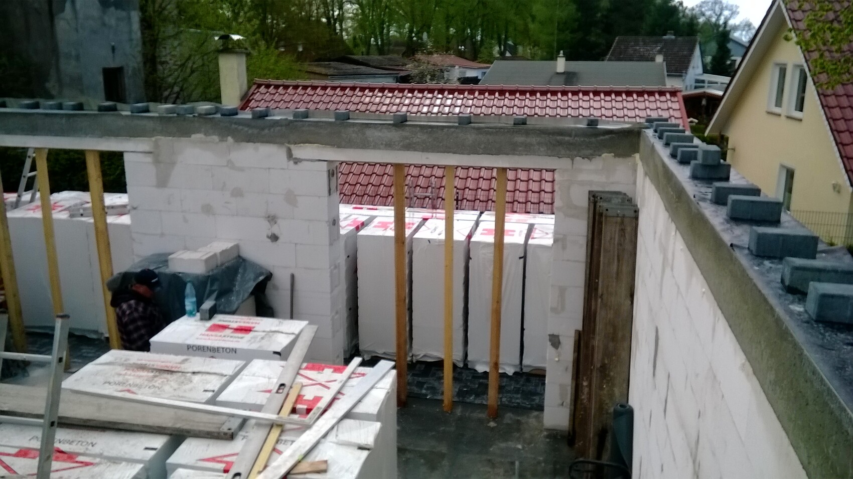Baustelle mit Porenbetonblöcken, Holzständerwerk und unfertigen Wänden