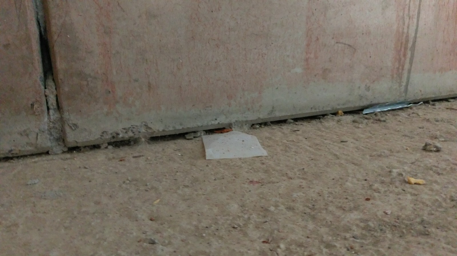 Rohbau-Bodenbereich an einer Baustellenwand mit Schutt und Kies