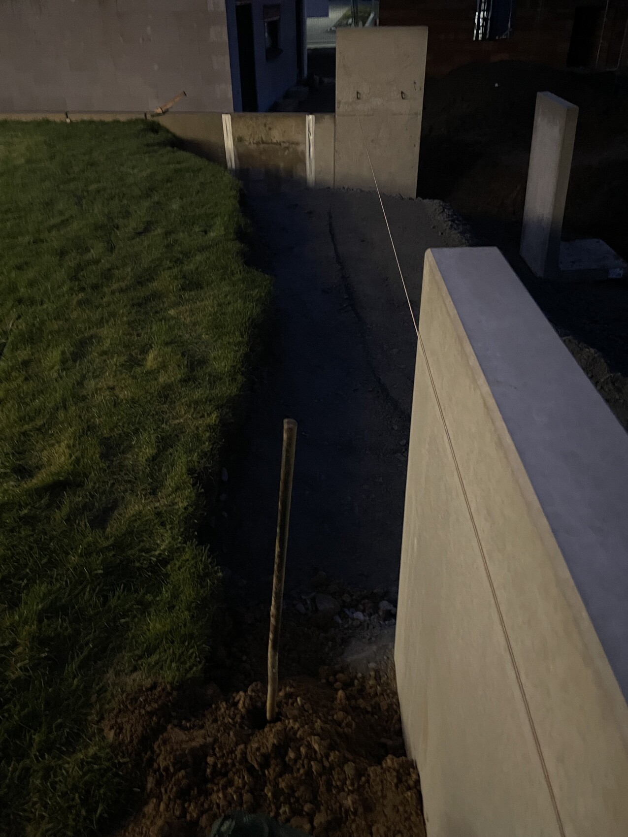 Baustelle mit Betonfundament, Stützwand und Ausrichtungsseil