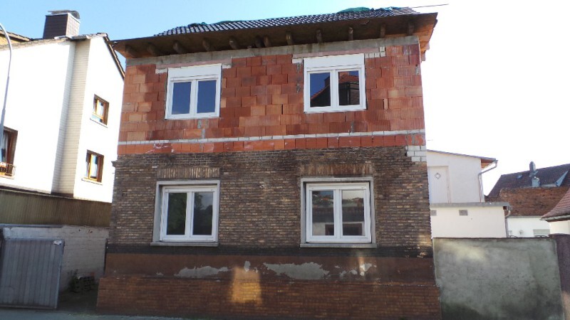Zweistöckiger Rohbau eines Hauses mit roter Backsteinfassade im Bau
