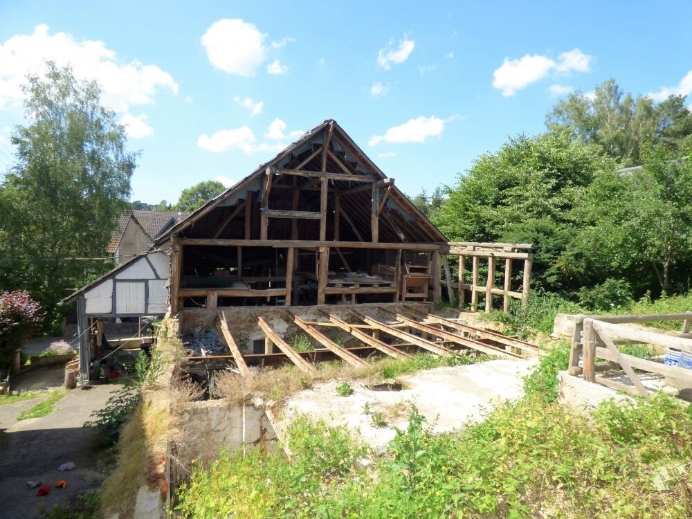 Holzrahmenhaus mit freigelegter Dachkonstruktion und Baugerüsten im Freien
