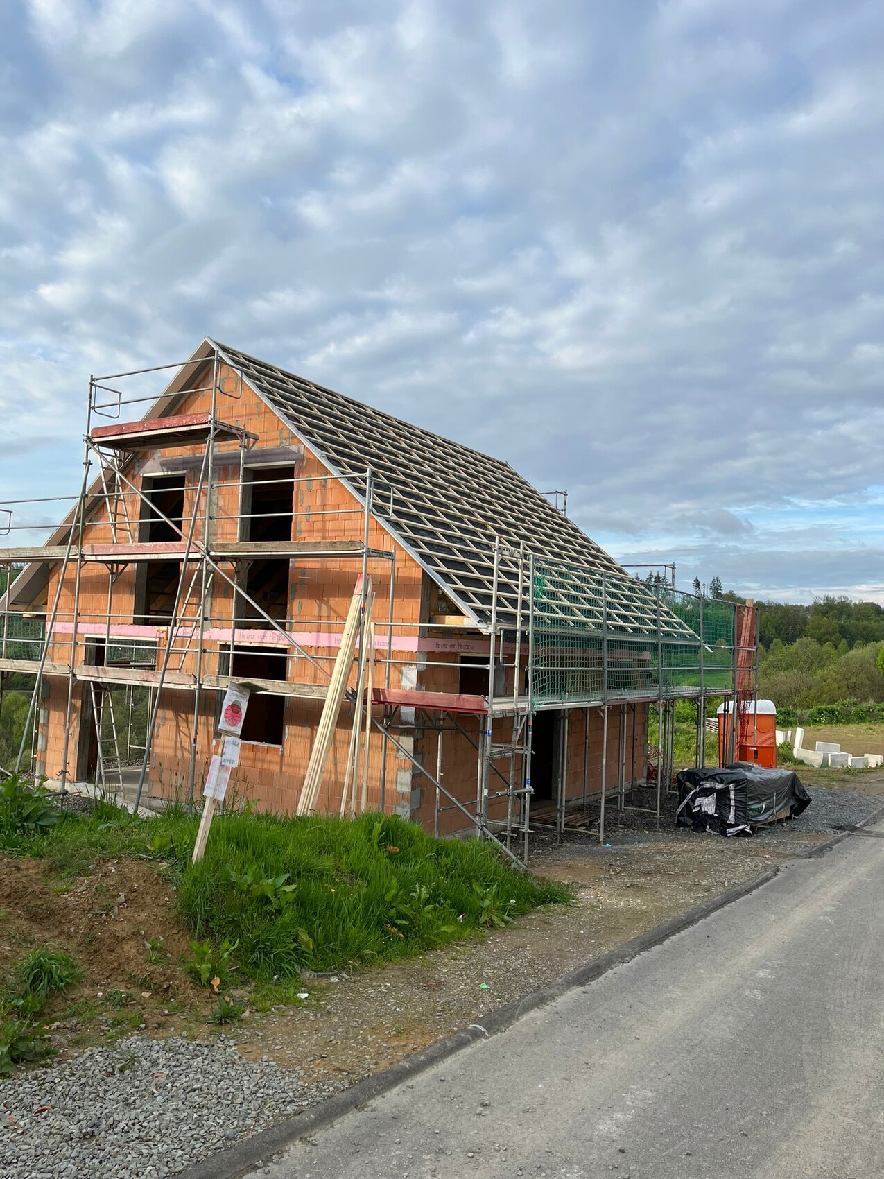 Unter Bau befindliches Einfamilienhaus mit Gerüst, Ziegelwänden und Dachkonstruktion