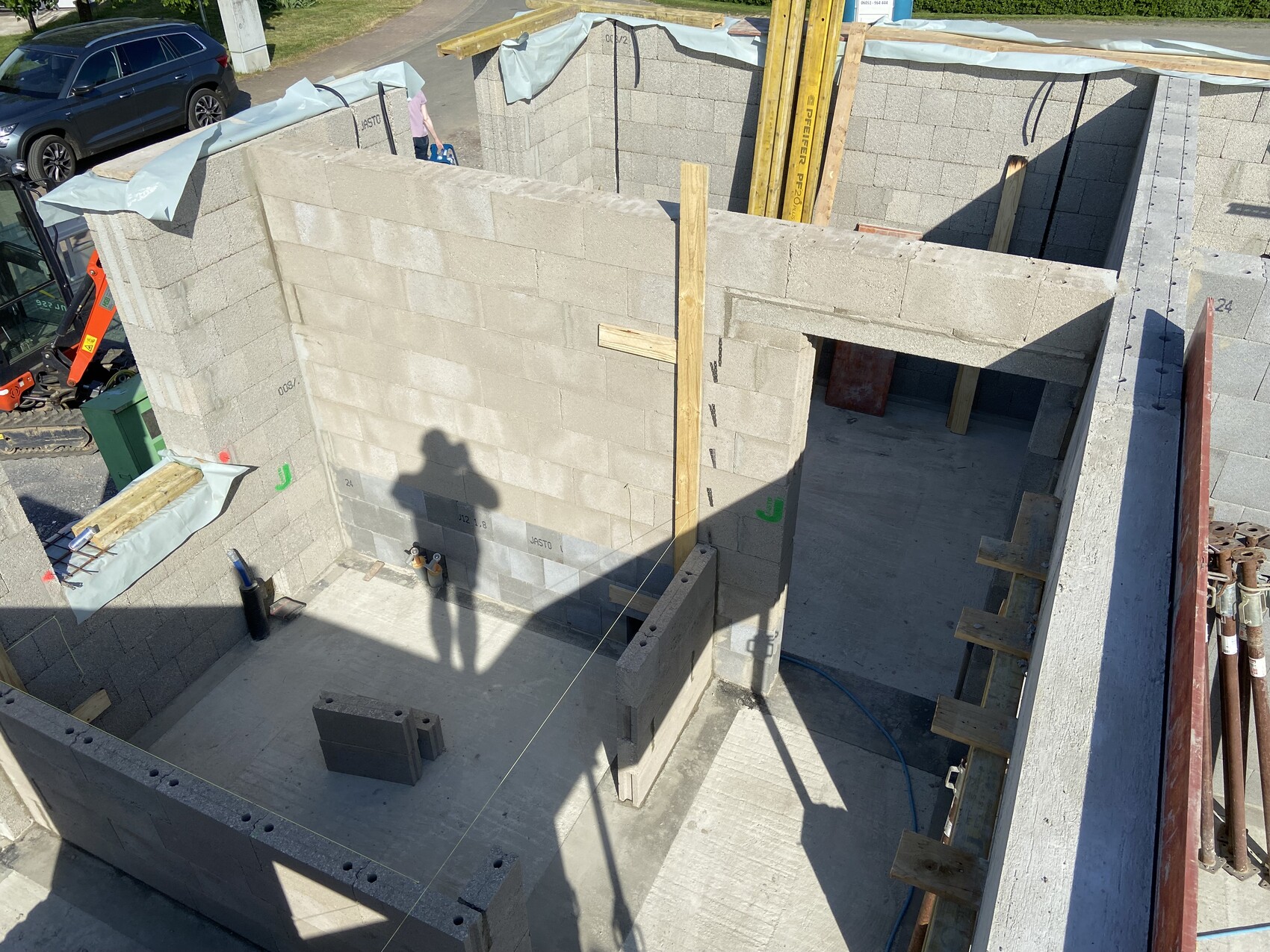 Rohbau-Baustelle mit Betonblockwänden, Holzstützen und Baugeräten
