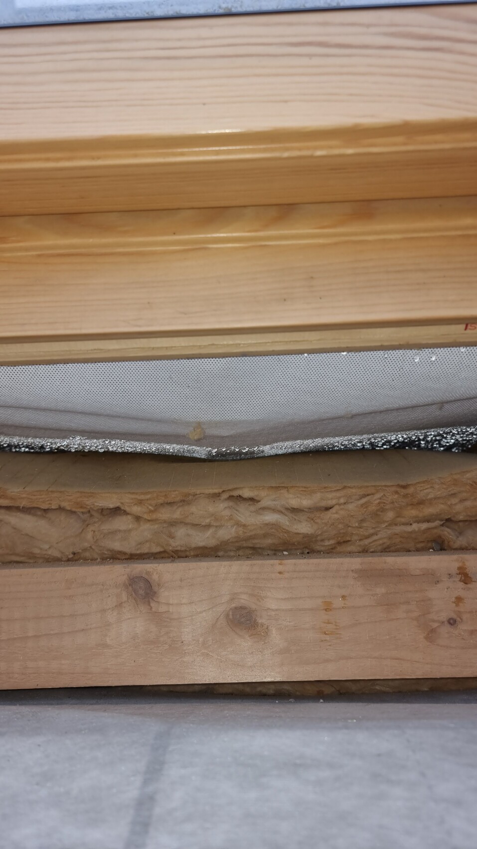 Querschnitt eines Wandaufbaus mit Holzverkleidung, Dämmstoff und Latten.