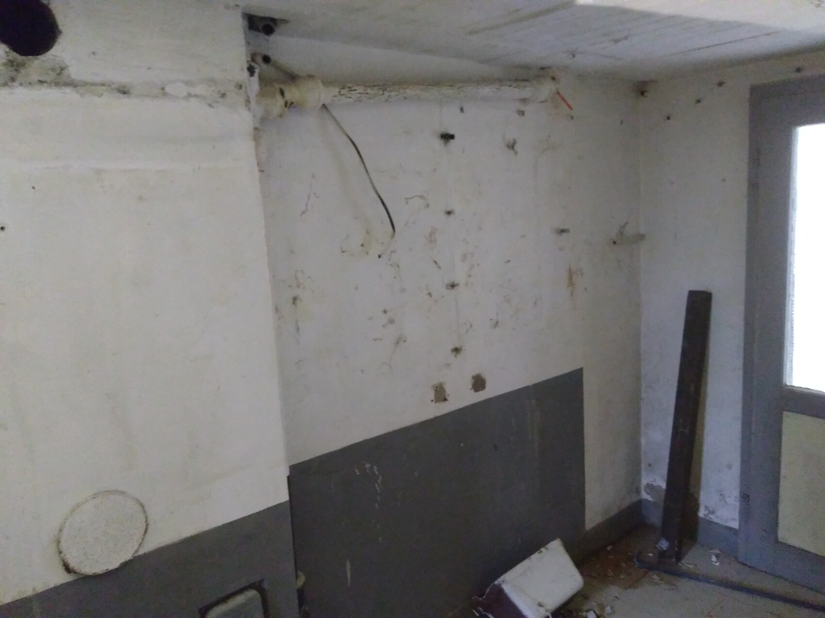 Unrenovierter Kellerraum im Rohbau mit Rohbauteilen, Kabeln und Bauresten.