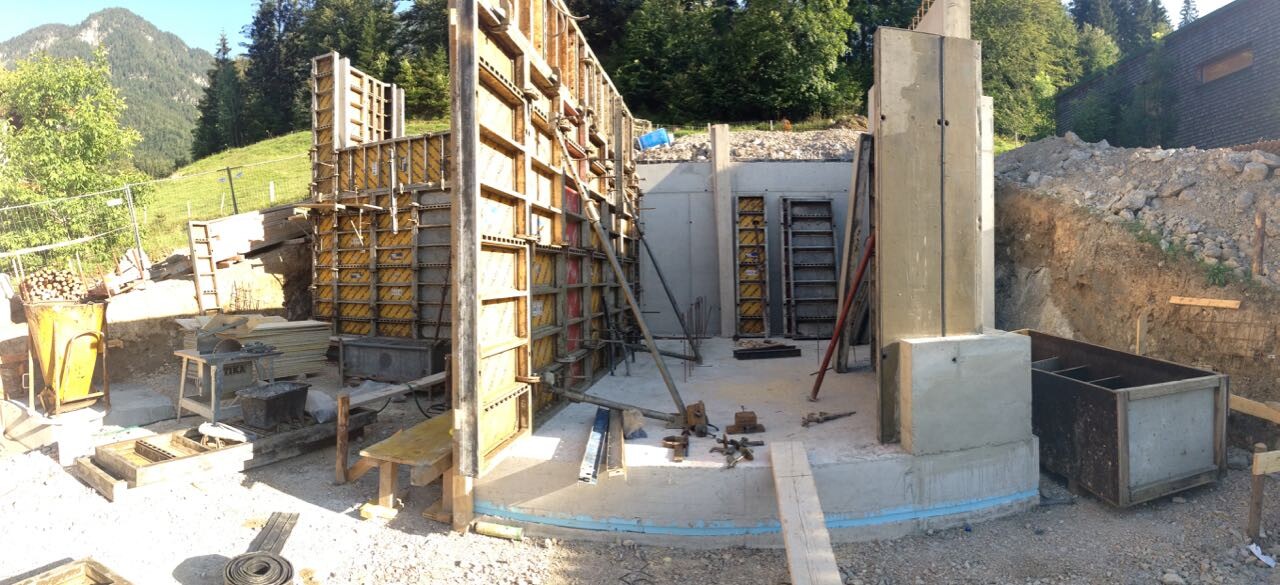 Baustelle mit Schalung, Betonfundament und Bauteilen für Rohbau