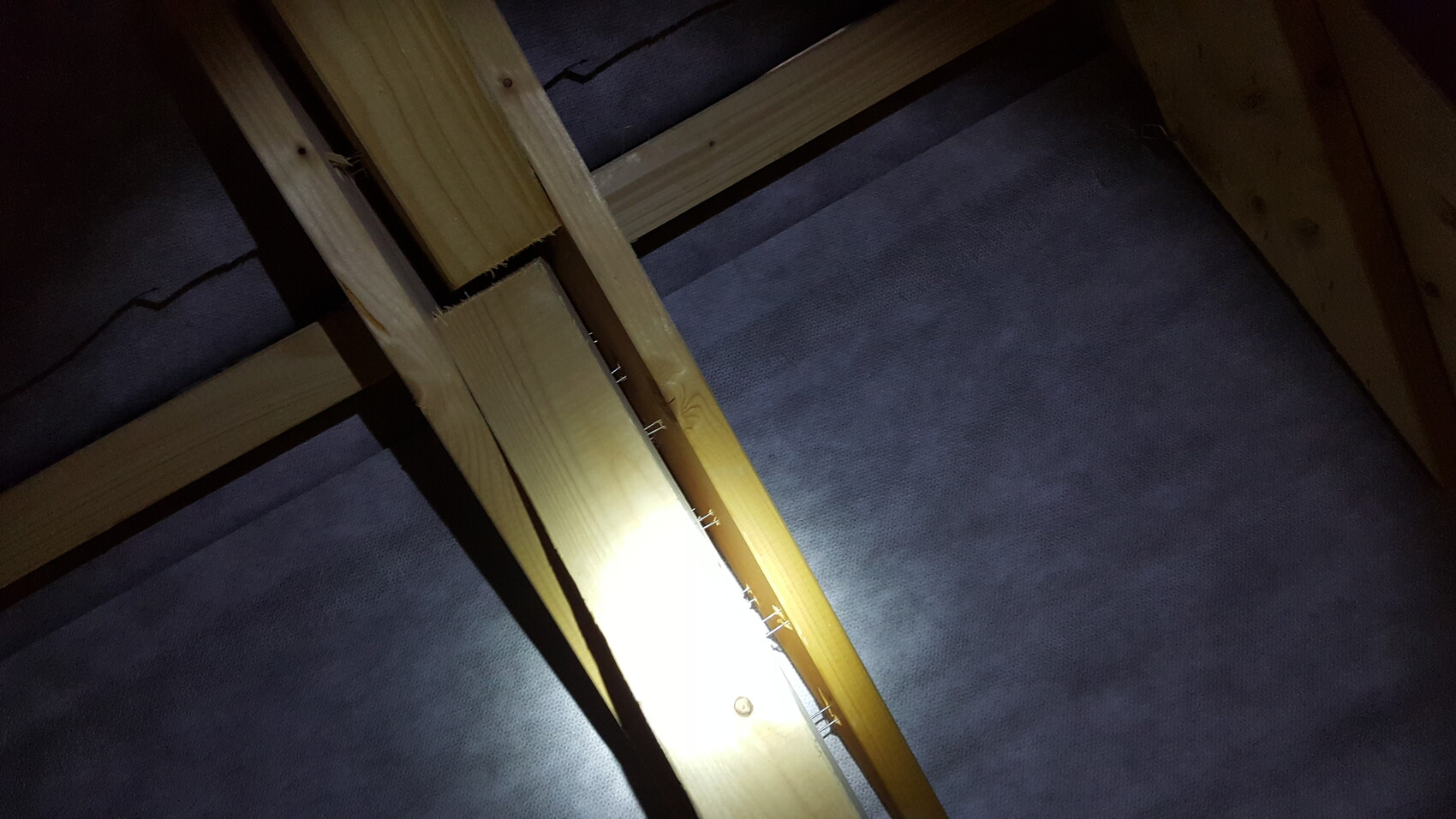 Holzrahmenkonstruktion im Dachboden mit Nägeln und Dämmstoff
