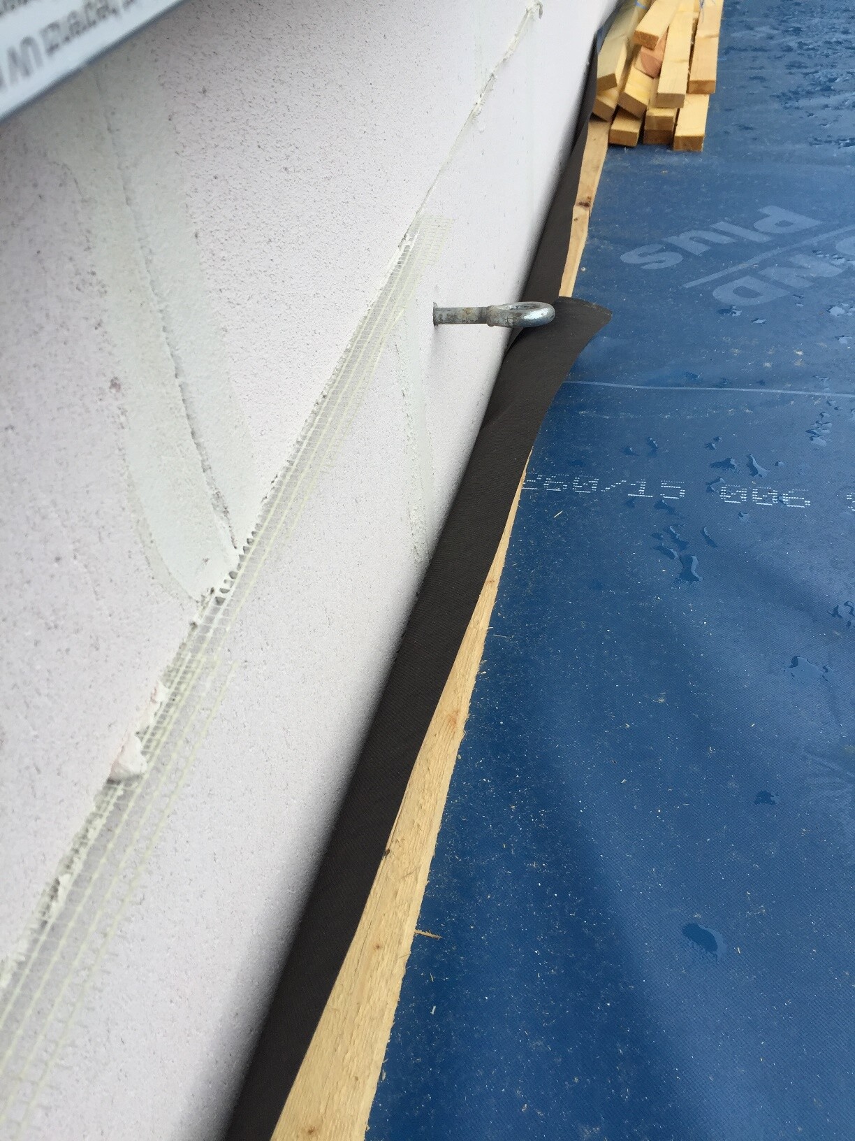 Außenwand im Rohbau mit Dämmung, blauer Baufolie und Holzlatten