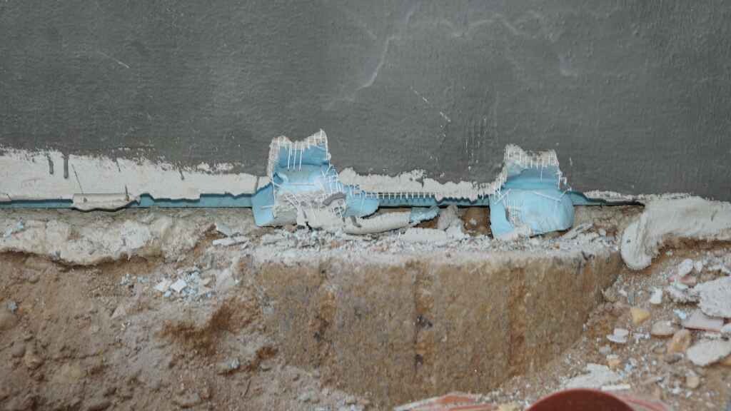 Baustelle mit Rohbaufundament und beschädigter Wandkante im Baufortschritt