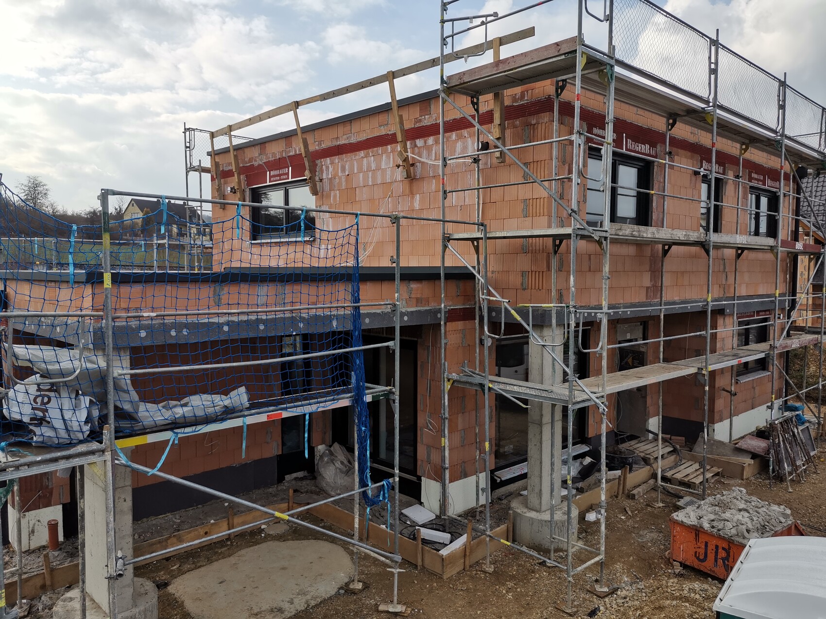 Rohbau eines Hauses mit Gerüsten und Ziegelwänden
