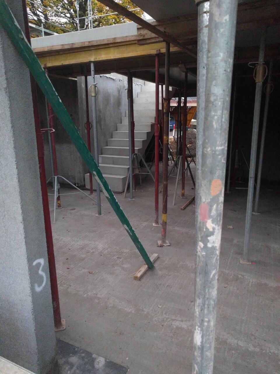 Baustelle mit unfertiger Beton-Treppe, Stützen und Baugerüst