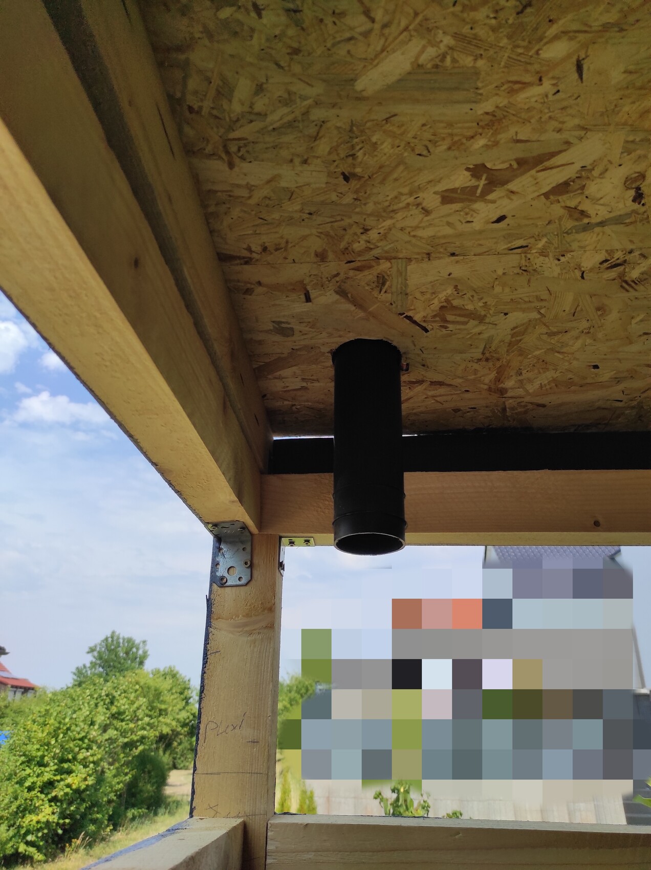 Rohbau-Bauunterkonstruktion aus Holz mit schwarzem Abluftrohr in Decke sichtbar.