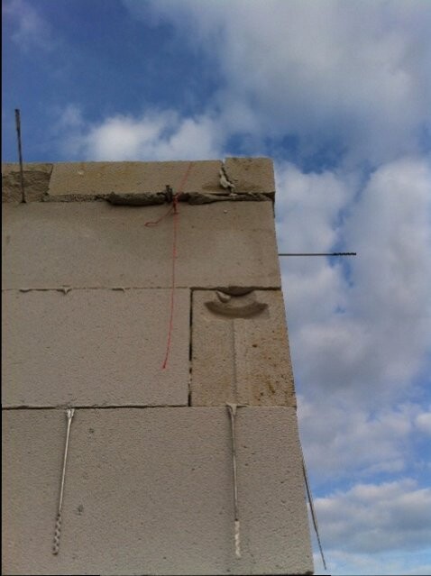 Rohbau: Betonblocke, Bewehrung und Schnur gegen blauen Himmel