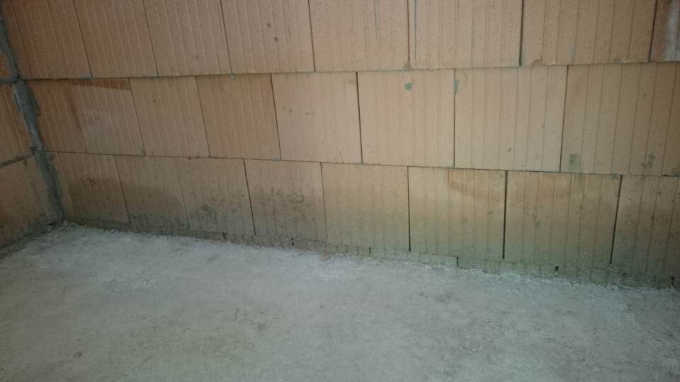 Keller-Rohbau: unbehandelte Wand aus Betonblöcken und grober Betonboden
