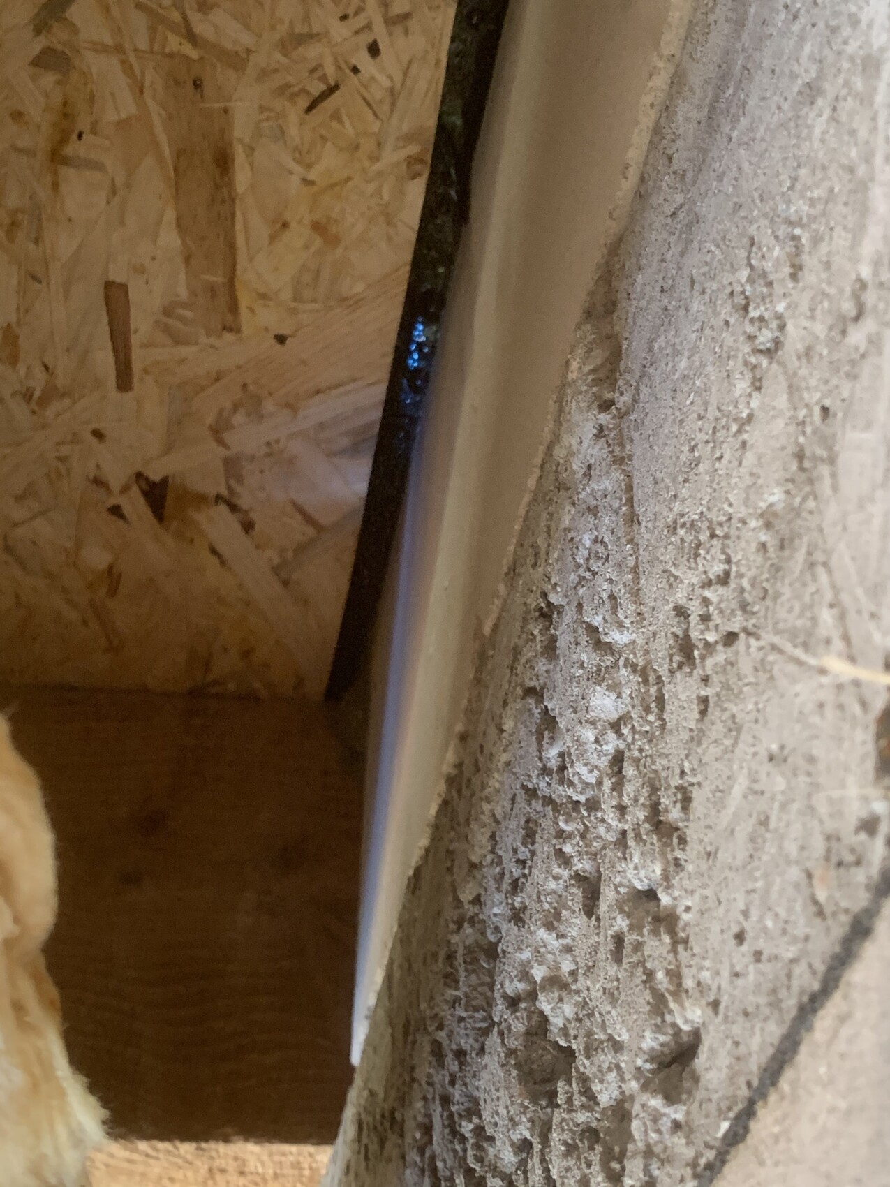 Bauwerksinnenseite: OSB-Platte links, raue Betonwand rechts, dünne schwarze Leiste dazwischen.