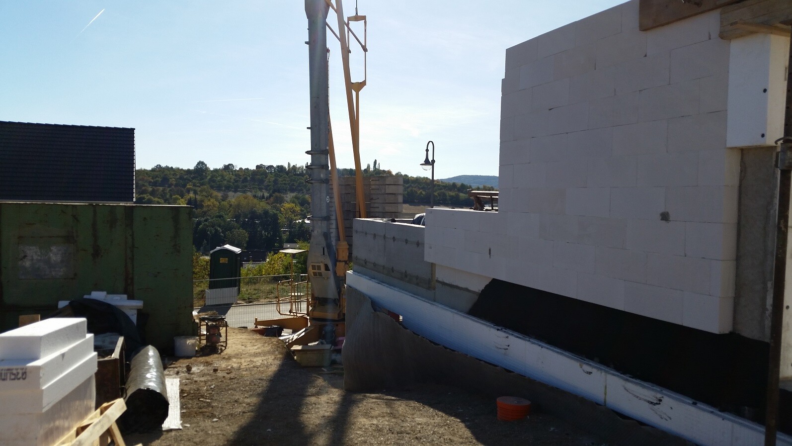 Baustelle mit weißen Betonsteinblöcken, Kran und Baugeräten