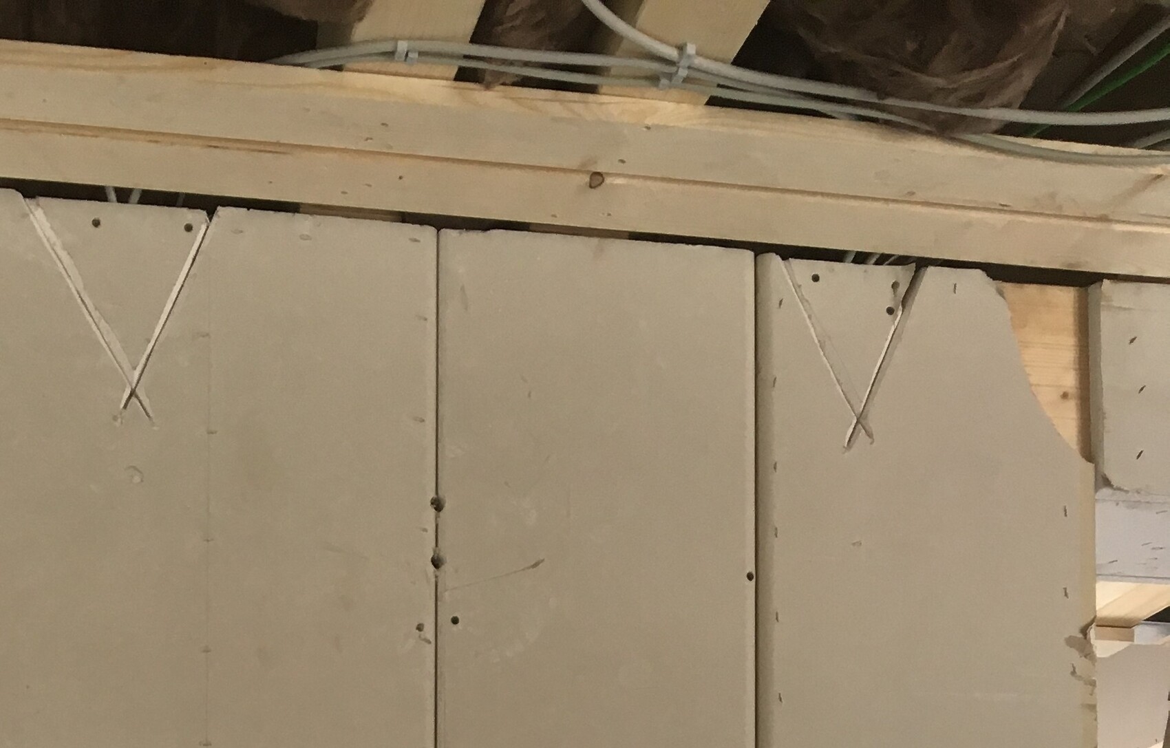 Rohbau-Wand aus Betonblöcken mit Holzbalken und Kabeln in Bauphase