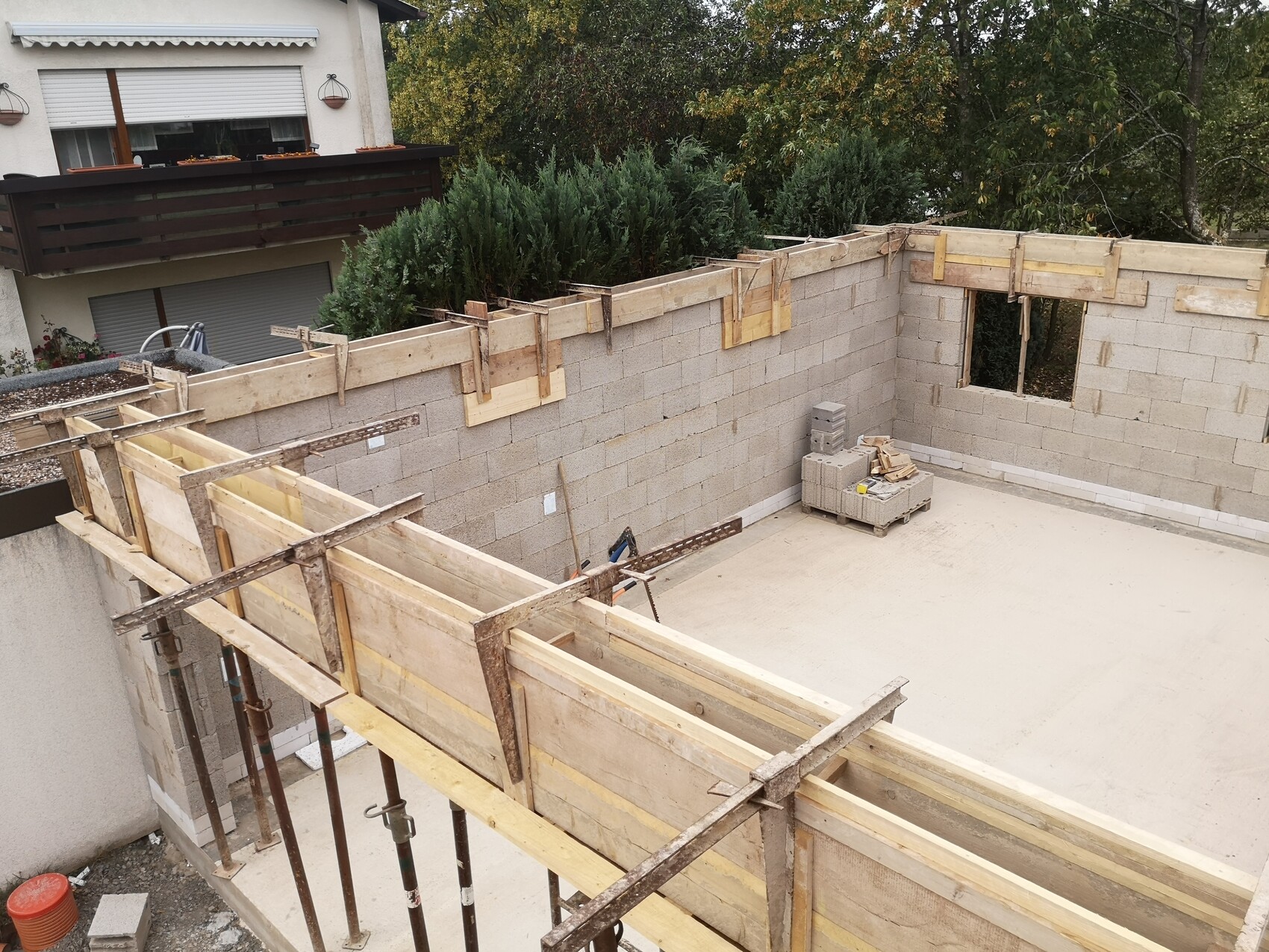 Kellerbau: Betonsteinmauer mit Holzformwerk und Baugerüst im Innenhof.