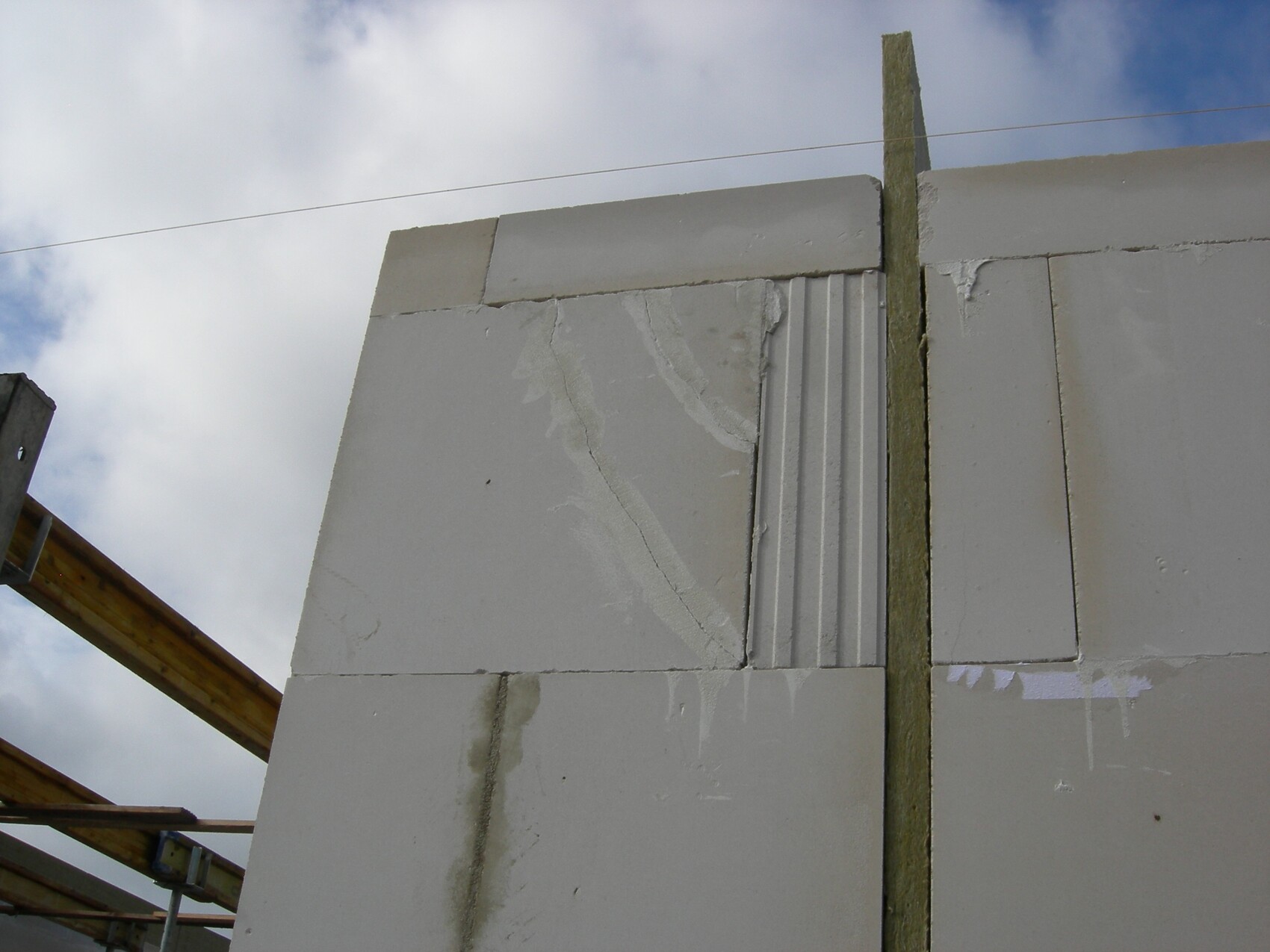 Halbfertige Betonblockwand auf einer Baustelle mit Holzbalken gegen Himmel