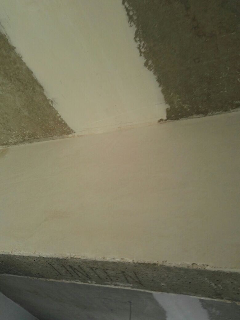Baustellenwand mit Putzresten und Sichtbeton im Rohbauzustand