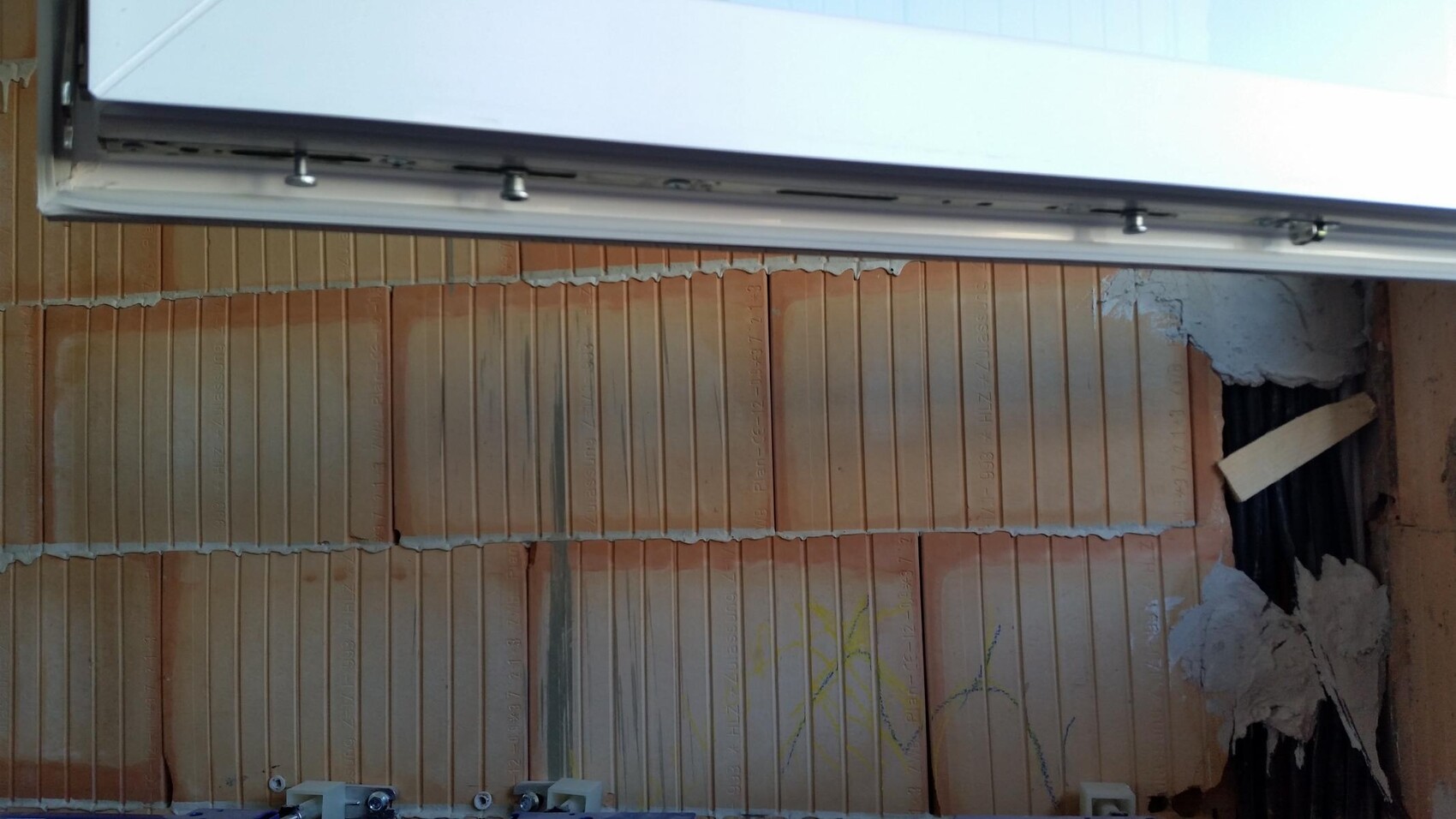Rohbau Innenansicht: Ziegelwand mit sichtbaren Fugen und Installationskanälen