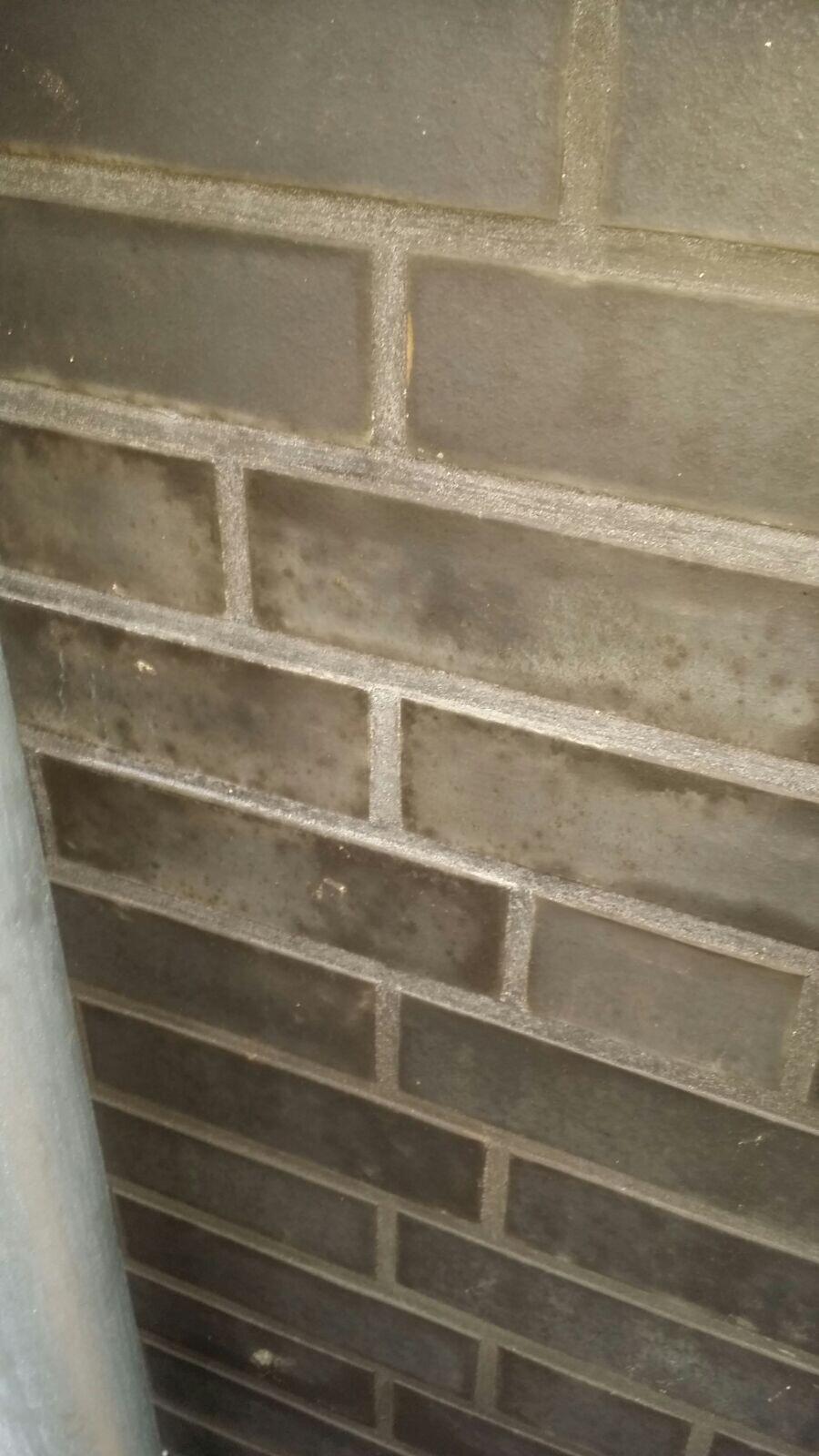 Nahaufnahme einer dunklen Ziegelwand mit grauen Fugen