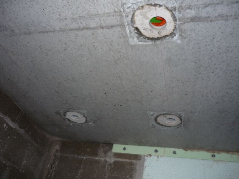 Betondecke mit drei runden Einbau-Objekten; oben rechts ist eine grün-rot markierte Anzeige zu sehen.