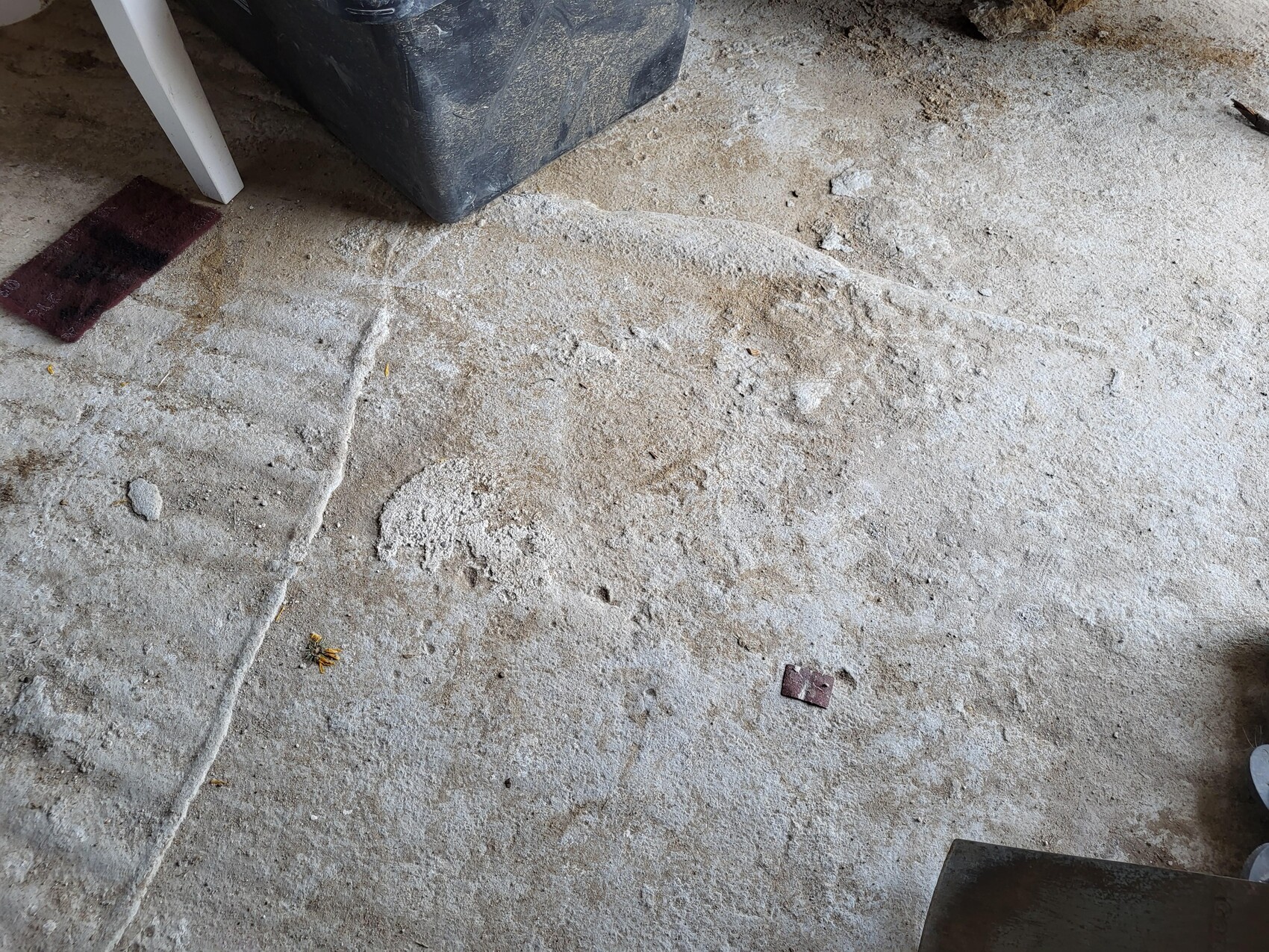 Baustellenboden aus rohem Beton mit Staub, Schmutz und Kleinteilen