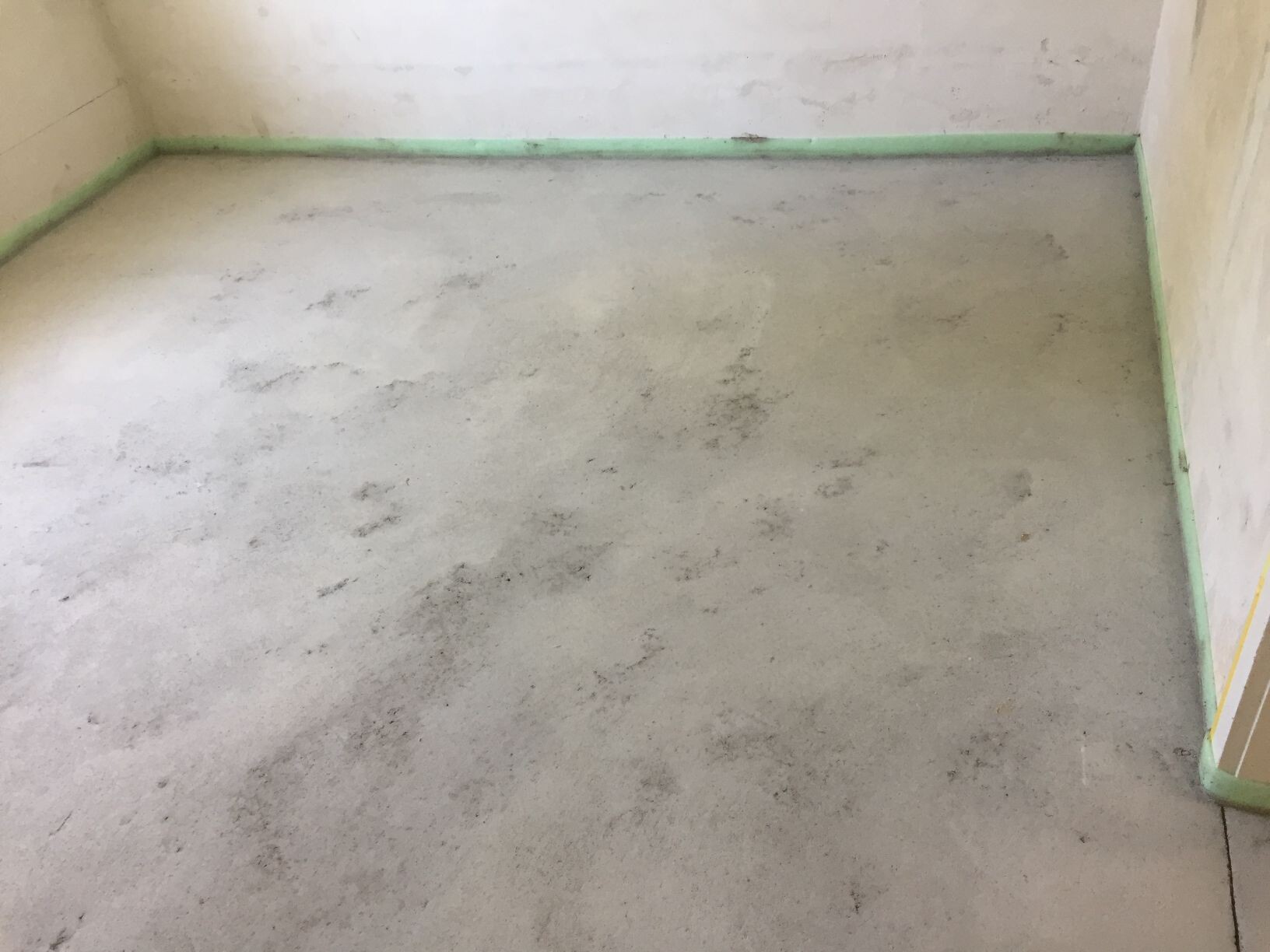 Unbearbeiteter Rohbau-Boden im zukünftigen Innenraum eines Hauses.