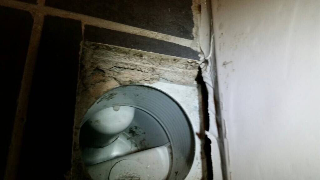 Rohranschluss in der Wand mit Putzabplatzungen und Baumaengel