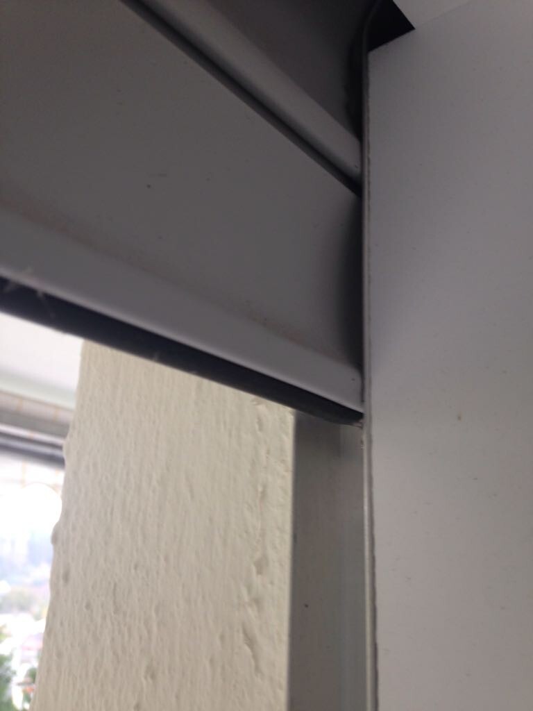Nahaufnahme eines Rollladenfensters mit Metallrahmen und Lamellen