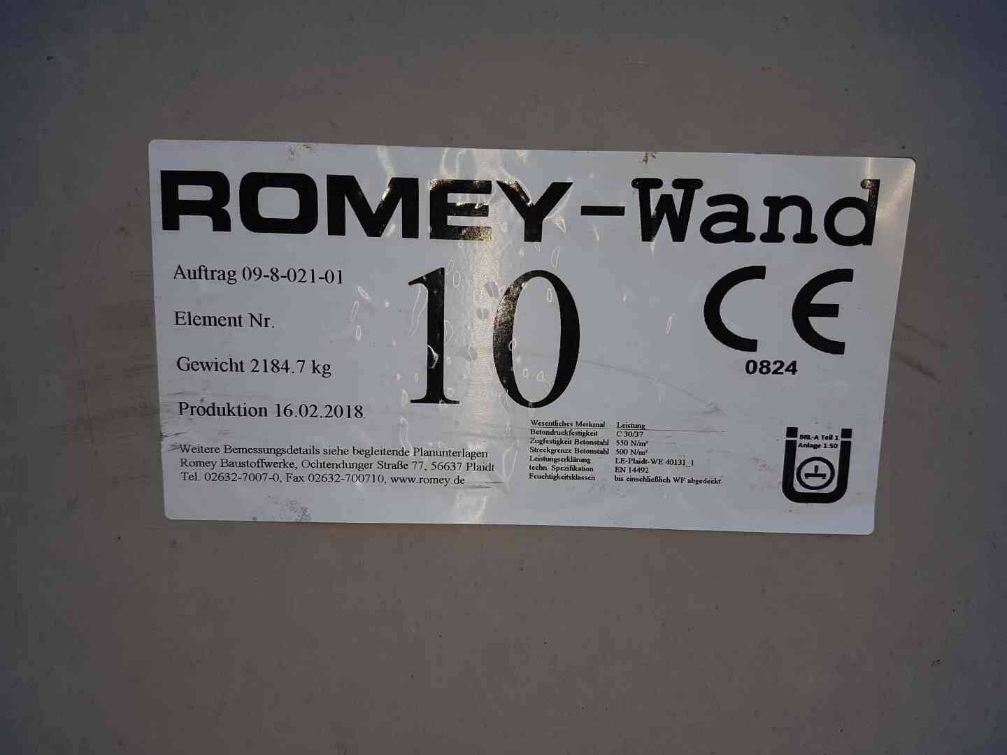 Weiße Herstellerplakette ROMEY-Wand an Betonwand mit CE-Zeichen und Gewichtsangaben.