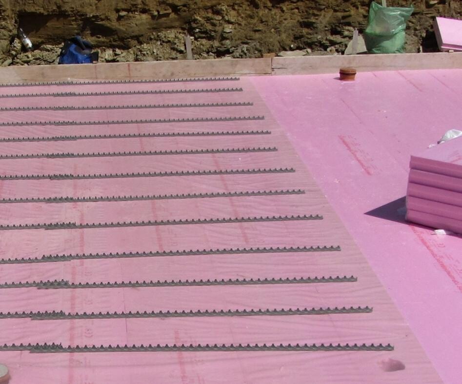 Rosa Dämmplatten auf einer Dachbaustelle mit Reihen von Dämmstreifen