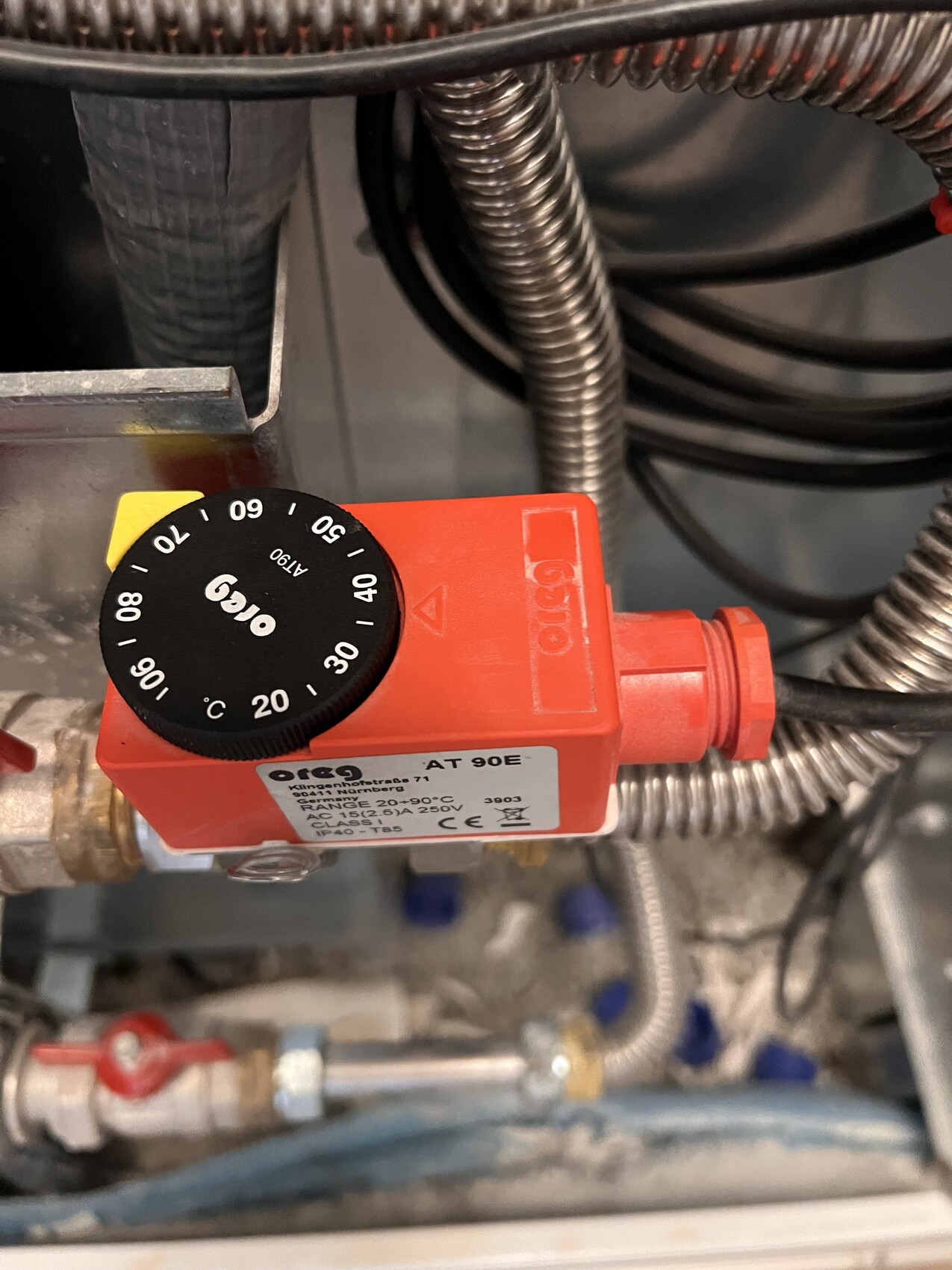 Roter Thermostatregler AT 90E mit Einstellrad 0–90 °C an Heizungsanlage, Kabel.