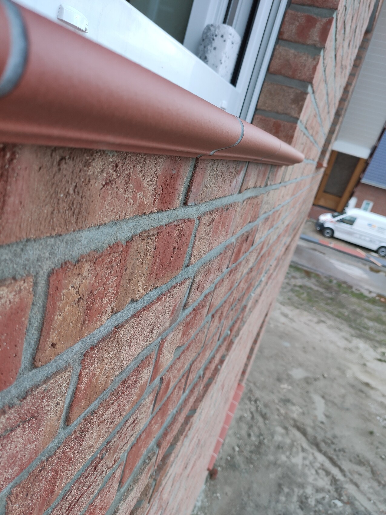 Außenansicht eines roten Ziegelhauses mit Fensterrahmen