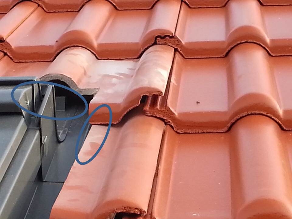 Nahaufnahme rotes Dachziegel-Dachkante mit Metallverblechung an der Dachkante und Fugen