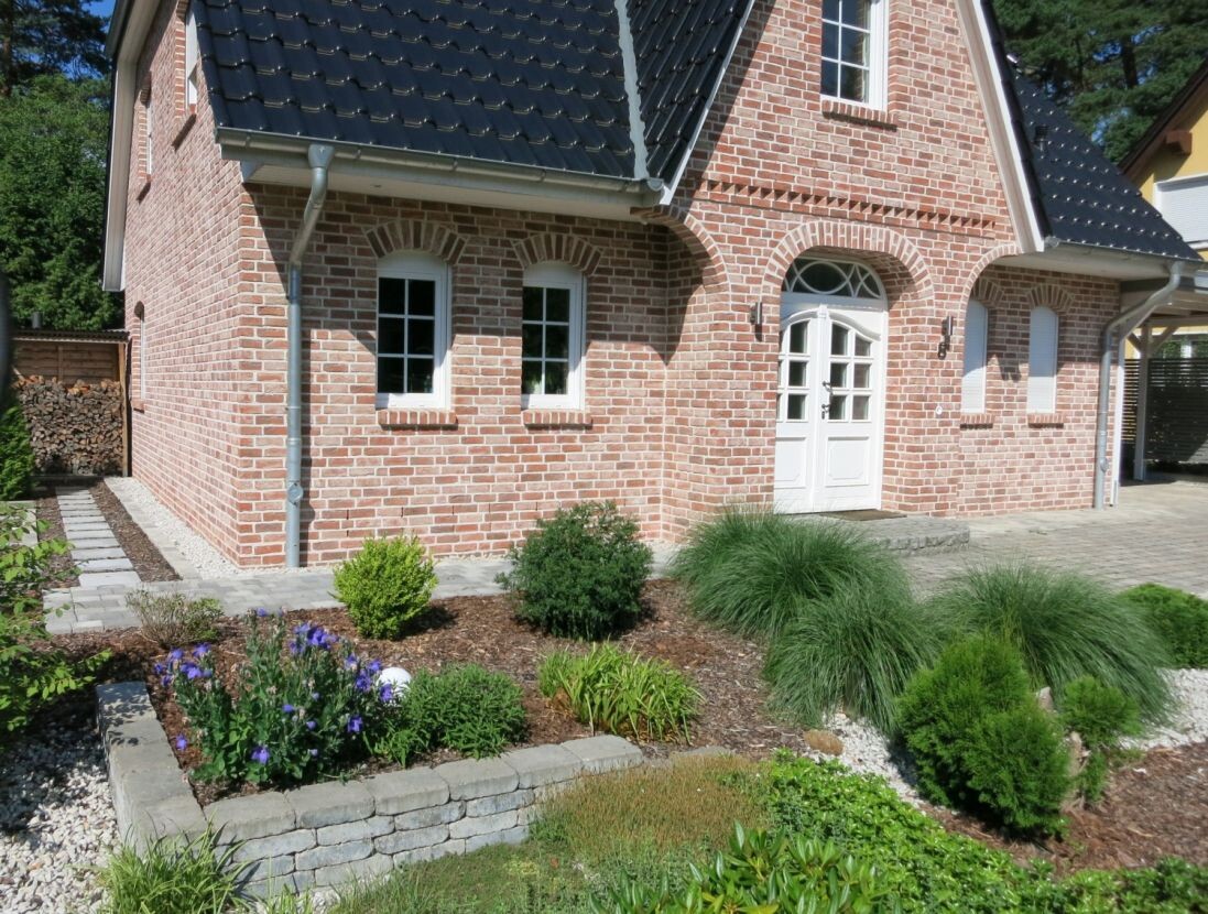rotes-ziegelhaus-vorderansicht-mit-garten.jpg