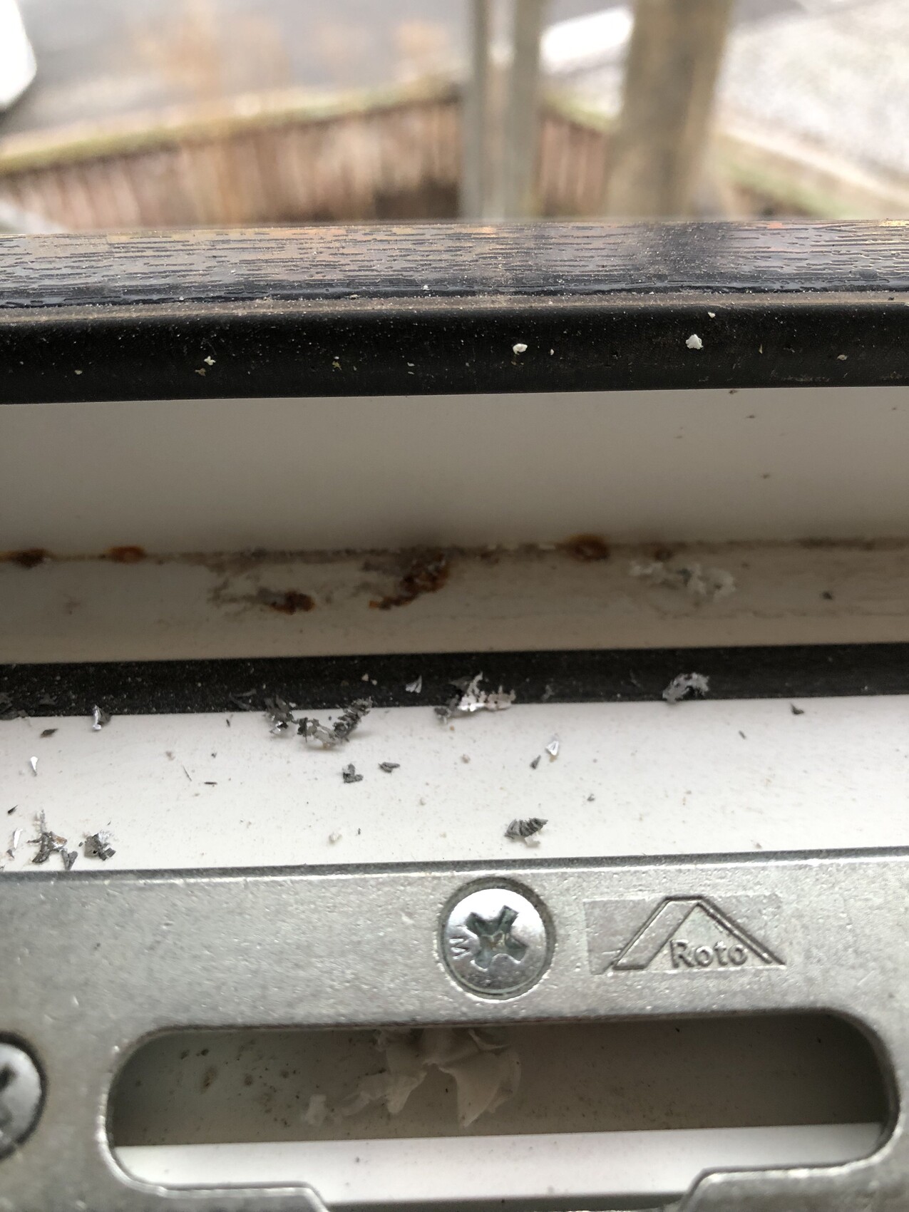Nahaufnahme eines fensterrahmens mit verschmutztem roto-beschlag und rost