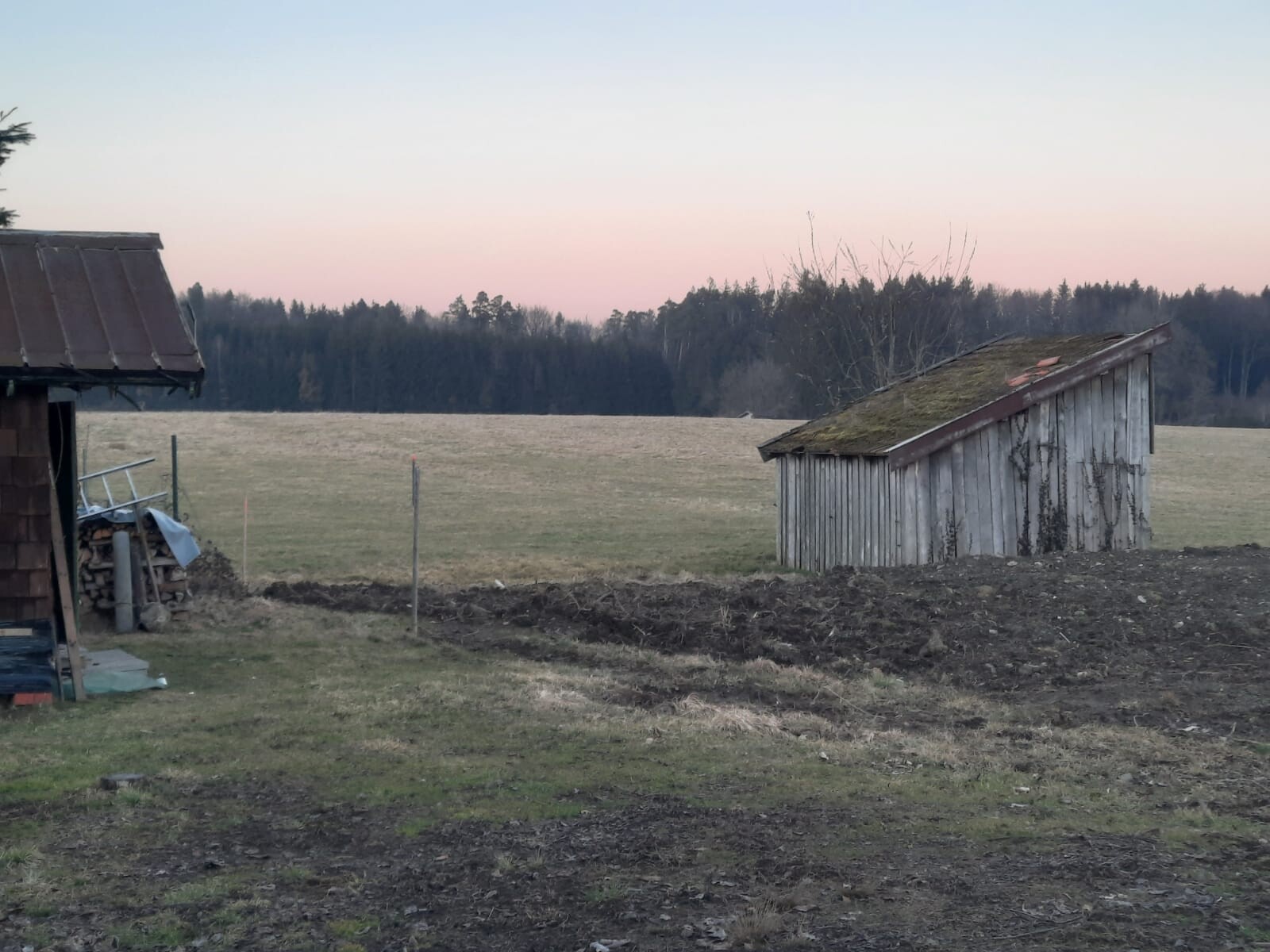 Laendliche Landschaft mit verfallener Holzsceune auf Feld bei Dämmerung