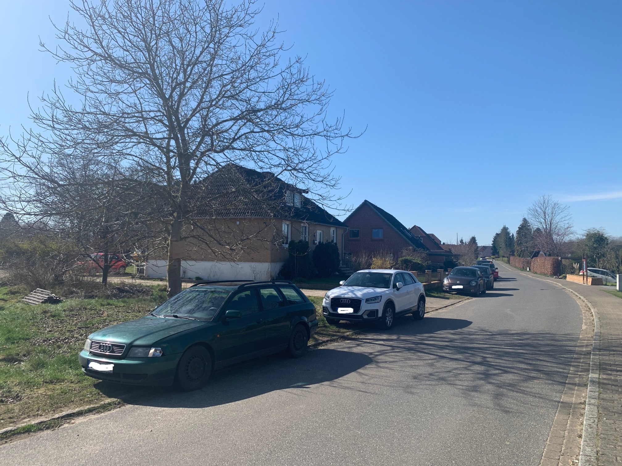 ruhige-wohnstrasse-mit-parkierten-autos-und-hauszeilen.jpg