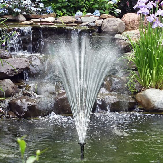Garten-Teich mit zentralem Springbrunnen, Wasserfächer nach außen, Steine drumherum.