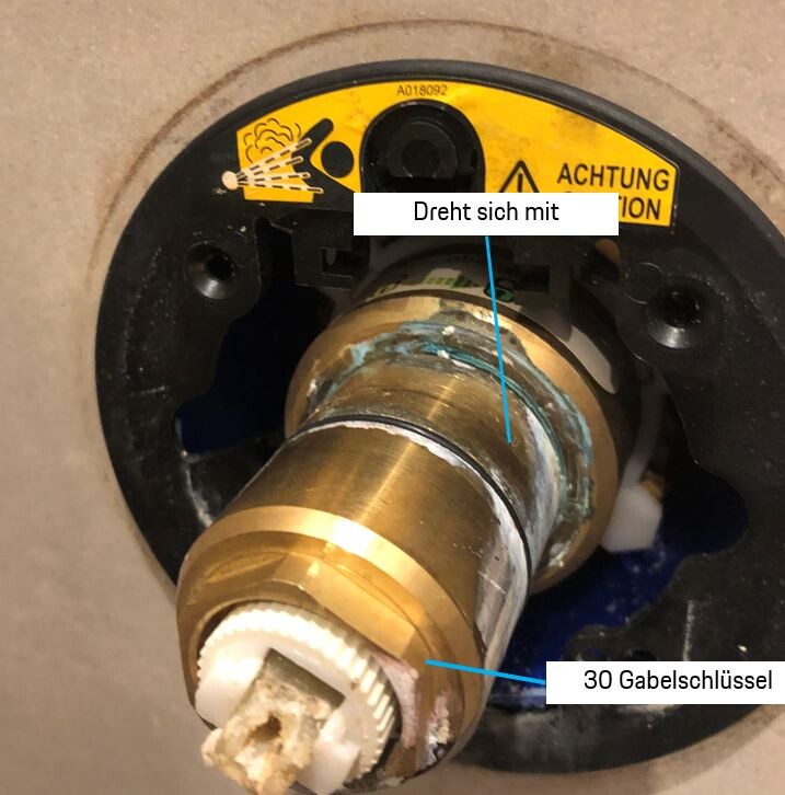 Nahaufnahme eines Sanitärventils mit Messingrohr in einer Badezimmerinstallation.