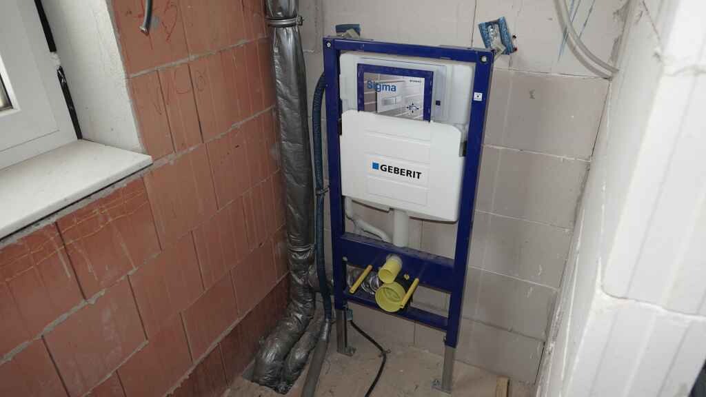 Geberit Wandspülrahmen aus blauem Metall mit Spülkasten in unfertigem Badezimmer.