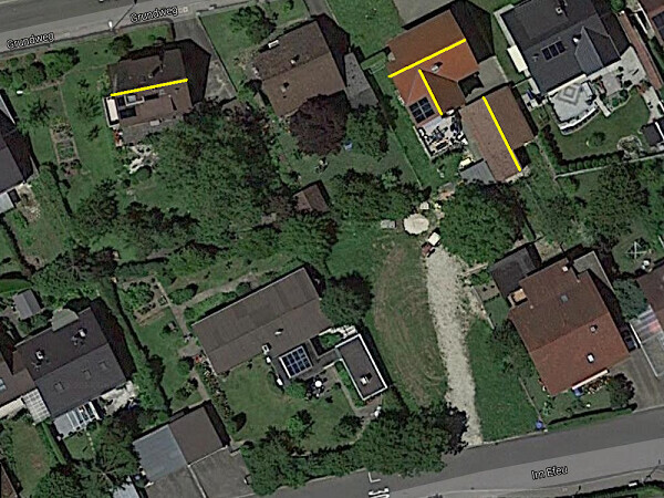 Satellitenaufnahme eines Wohngebiets mit Häusern, Gärten und gelben Markierungen.