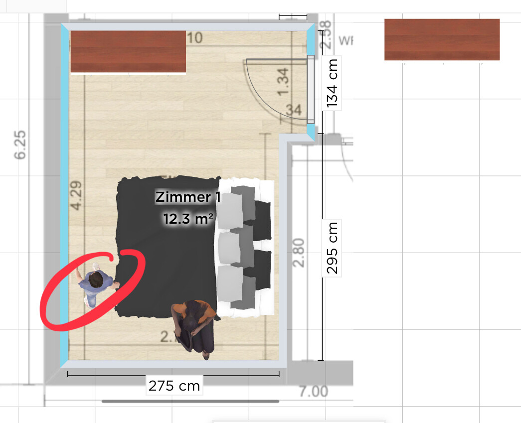 Zimmer 1 Grundriss: Bett, zwei Personen im Raum, rote Markierung links vom Bett.